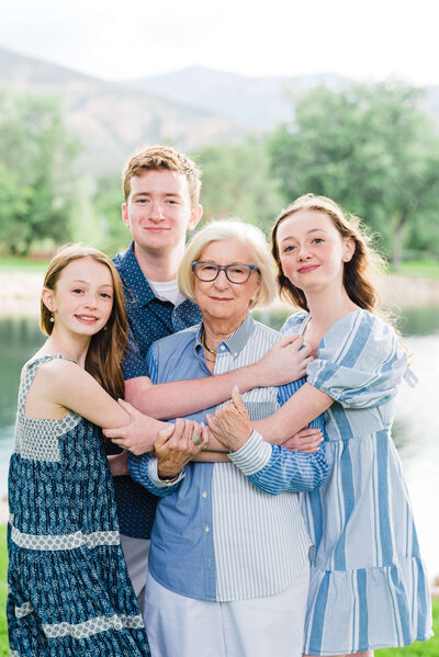 grandma and grandchildren hugging together and smiling for photo