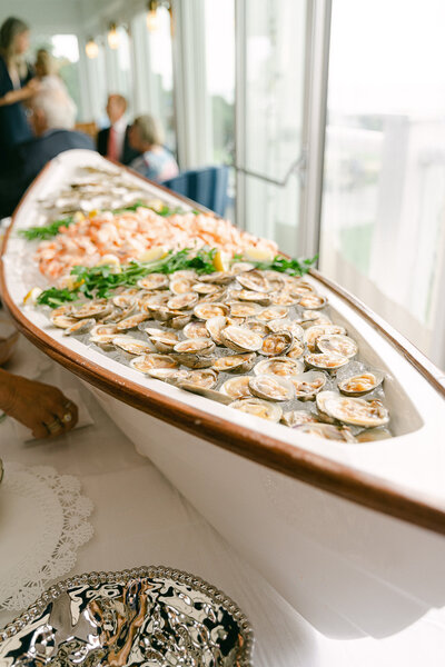 Canoe filled with shrimp and oysters during a cocktail hour at Hyannisport Club in Cape Cod