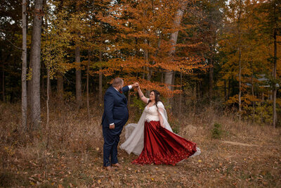 Groom twirls bride in red wedding dress