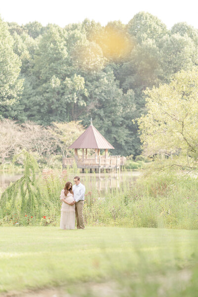 expecting couple in the middle of a garden during Vienna, Virginia maternity photos