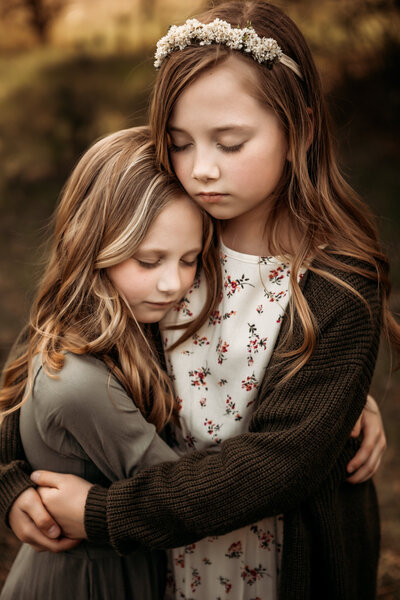 sisters hugging in field in central pa