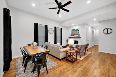 Open concept dining room and living room with TV in this three-bedroom, two-bathroom home with fully stocked kitchen, large backyard, grill, and basketball hoop in downtown Waco, TX.