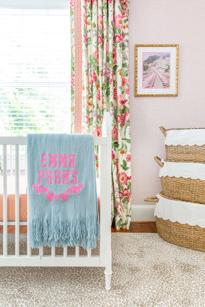 Feminine nursery with floral curtains and custom blanket