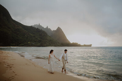 Couple walks down Tunnels Beach in Kauai for their elopement