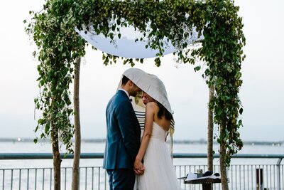 Couple-stands=under-chuppah-heads-covered-during-ceremony