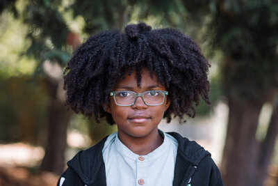school portrait of a boy in classes with a slight smile at an Oakland Elementary school