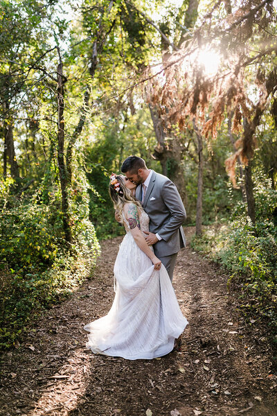 Bride and groom kissing in the forest