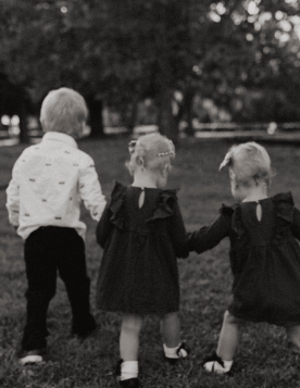 Three little children walking holding hands together