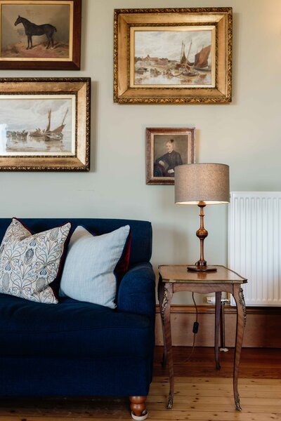 The main lounge of Kinclune House - a sofa and photo frames are photographed closely.