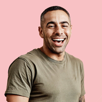 Smiling  fit man wearing green against pink background