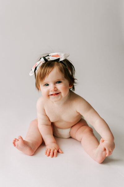 The cutest little sitter on a white background  captured by Chelsey Kae Photography