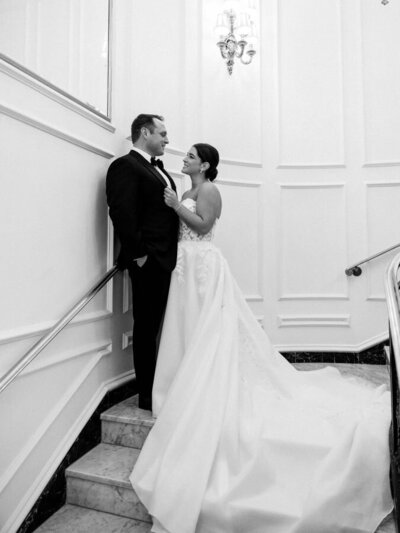 Bride and groom pose at the landing of the steps at the Willard intercontinental