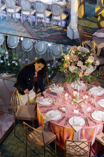 Shot of the Owner of Tinted Events Jacqueline Vizcaino detailing a guest table before the doors open