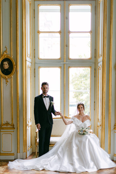 Bride and groom posing in front of large window at the luxury palace Vienna executed by ECLAT Destination Weddings