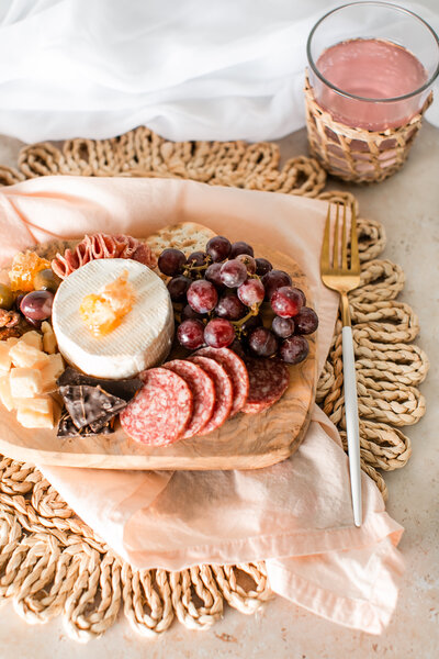 Assorted meats, cheese, and fruit on a small plate