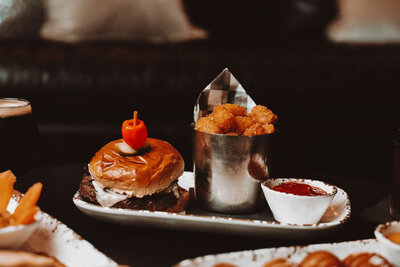 Delicious crispy chicken wings served with a side of dipping sauce, paired with an ice-cold beer garnished with a lime wedge, set on a rustic bar counter.