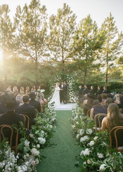 groom and blonde bride in white wedding dress and pink flowers