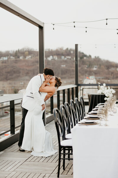 Hispanic Wedding Couple Kissing on a Pittsburgh Rooftop with Dinner Set