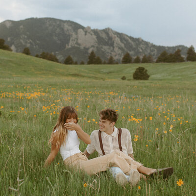 The couple sit together at sunset in the sands of Klondike park for their engagement photos.