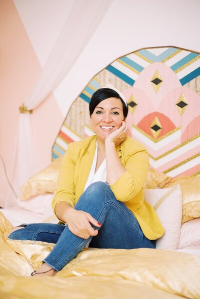 A headshot of Dolly DeLong Education at the Nashville Pinky House for her branding session she is wearing a mustard yellow jacket and a knotted headband