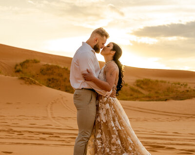 A couple kissing during their elopement at sunset at the coral pink sand dunes in Utah