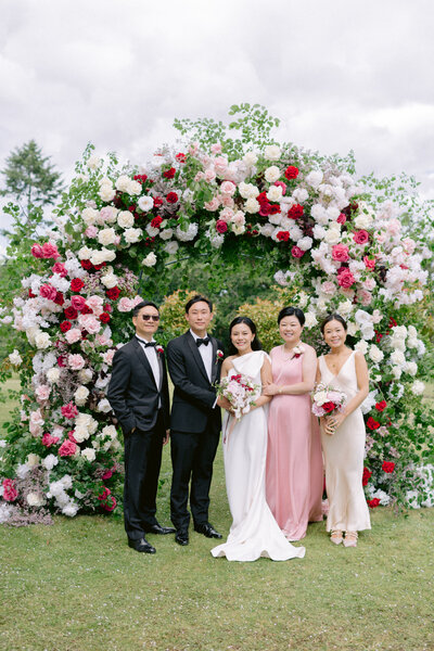 wedding family formal photo with luxury large flower arch with red and white roses at botleys mansion