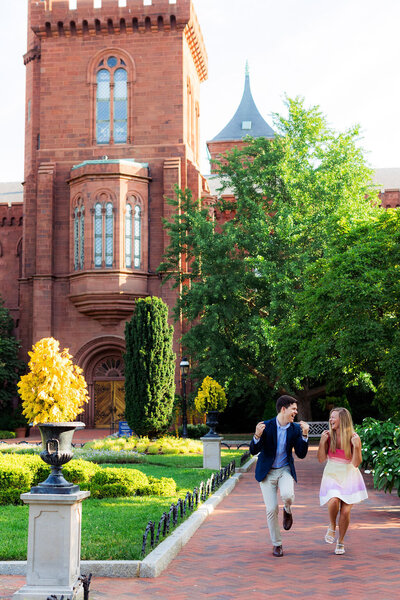 A couple dances their way down the street while snapping fingers in front of the Smithsonian Castle