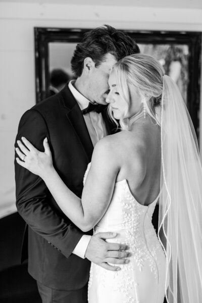 Groom holding bride close 