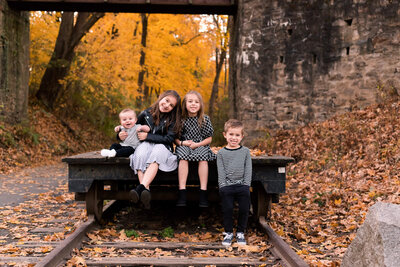 Kids sitting on a railroad car during fall