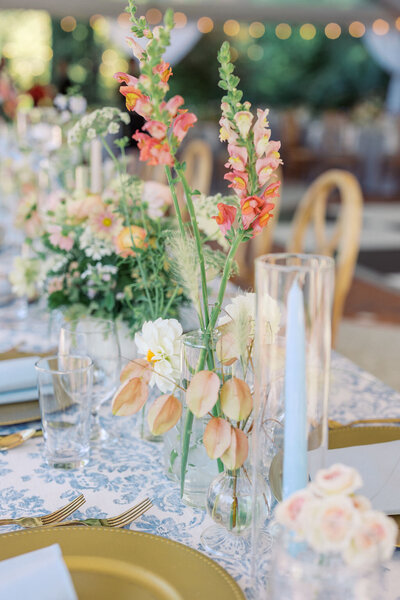 Elegant pastel florals on wedding reception tables with blue and white tablecloth