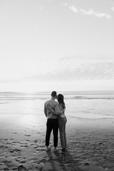 couple looks at ocean on the beach