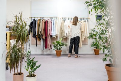 Vêtements sur un présentoir avec une femme devant le présentoir