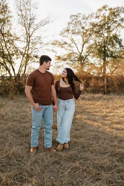 Romantic couples photography in Aiken SC - playful candid moment in an open field at sunset.