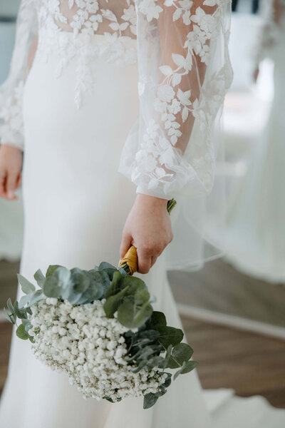 Bride in vintage lace wedding gown holding bridal bouquet in Terrell, Texas bridal suite
