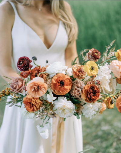bride holding bouquet with fall colors
