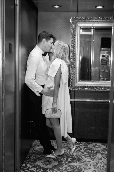 Black and White of Bride and Groom Kissing in Elevator photo