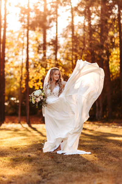 Bride tossing her flowy wedding dress with the wind at sunset in Culumbus, GA.