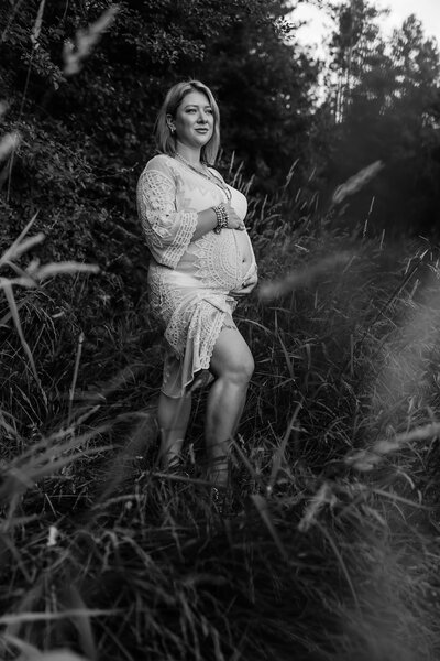 Pregnant mom holding belly in white dress during maternity session in Wheaton, IL