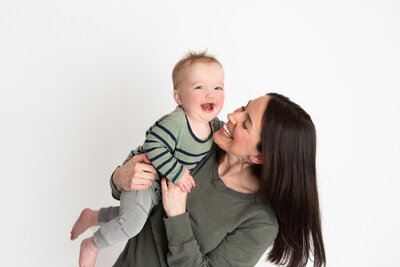 Edmonton mom laughing with her son simple white portrait