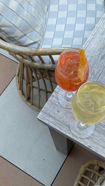 two glasses of mocktails on the top edge of a wooden table