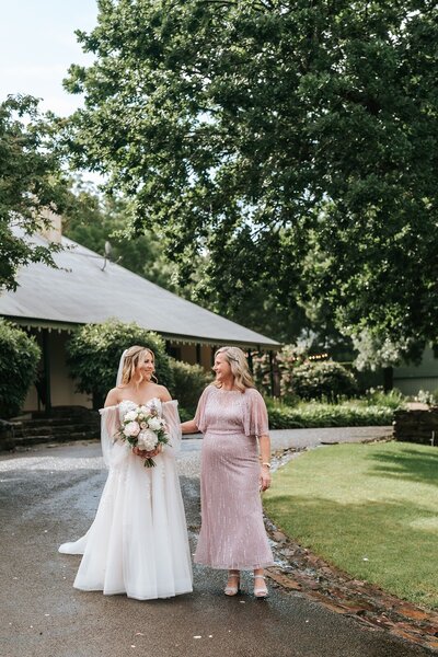 Bride and her mother at a micro wedding, bride holding a bouquet of white flowers