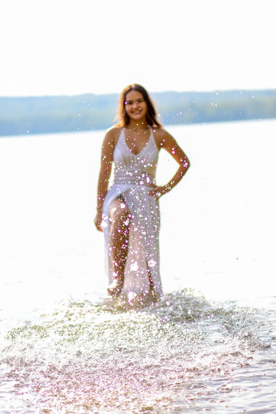 Photo of girl kicking up water | Senior Session