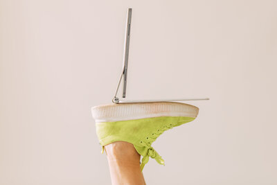 Laptop placed on green shoes in creative flat lay, styled brand photo for web designer Kirstin