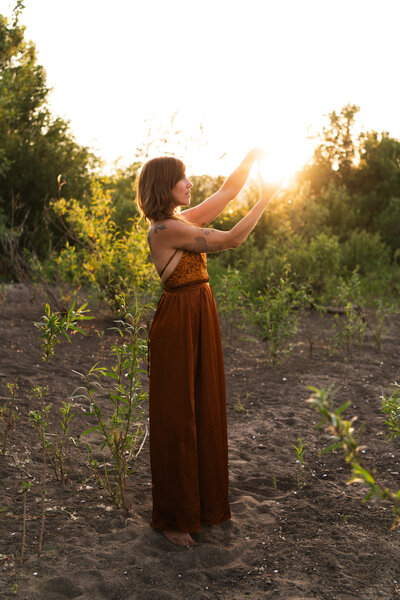 mentor, healer, guide touching branches with sunburst behind her