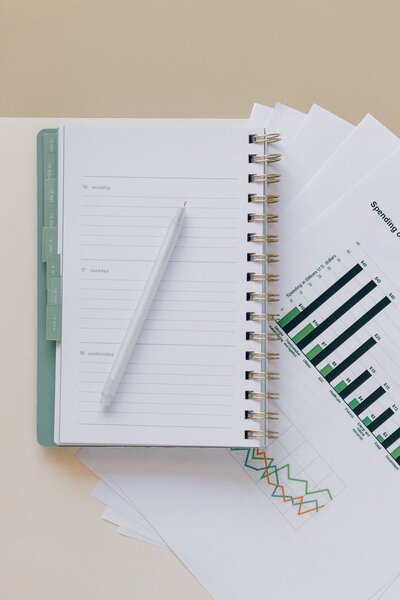 day planner with a pen business graph behind