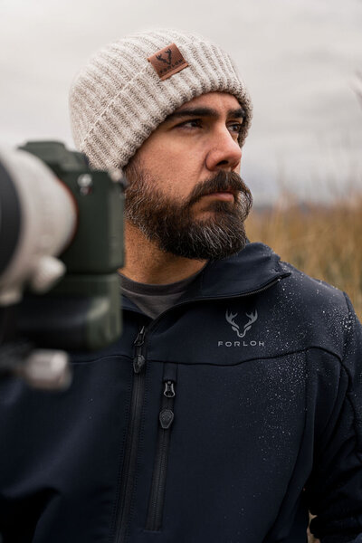 Staccato 2011-style handgun with tan textured grips, surrounded by ammunition, magazine, and suppressor, captured by Joseph Mayden for tactical branding and product marketing.