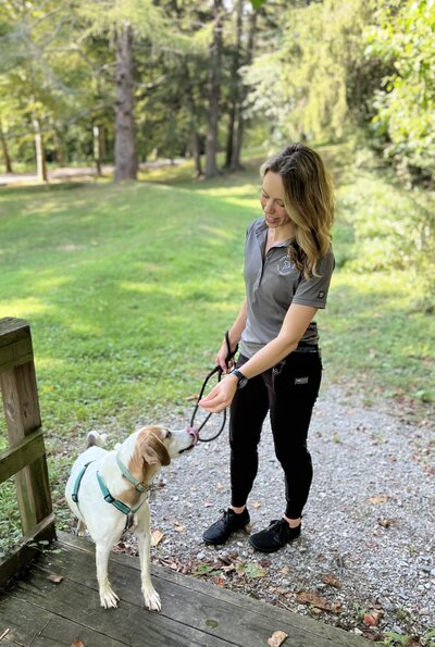 Dog trainer Michelle Pennarola walking outside with a dog