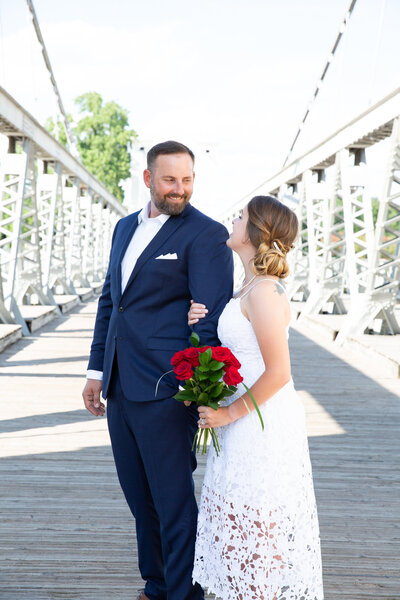 An Austin-based wedding photographer captures a couple's precious moments as the bride and groom stand on a romantic bridge.