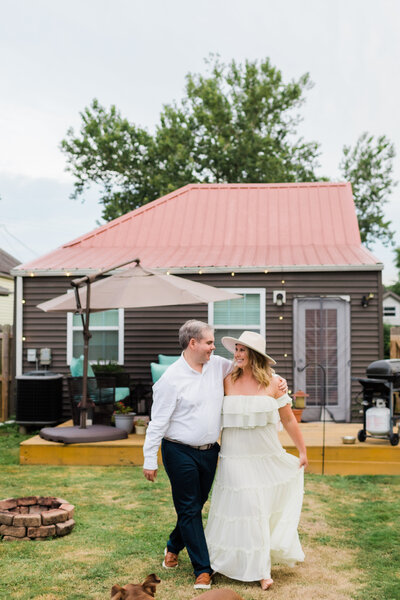 A couple walk in their backyard during a candid photo shoot