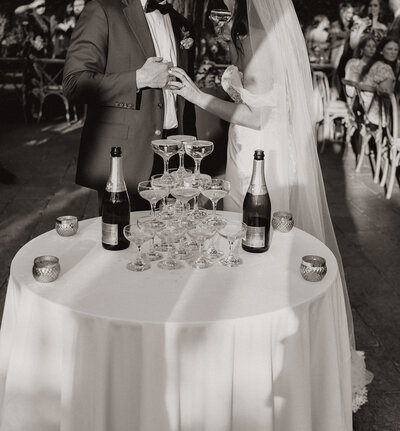 high-end wedding with bride and groom next to champagne tower